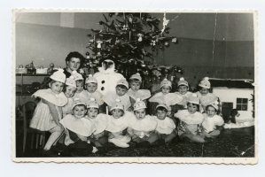 Rok 1962. Przedszkole nr 1, ul. Czołgistów, grupa najmłodsza. Zofia Bladowska (w przebraniu bałwanka) i Stefania Woźniak – pomoc wychowawczyni. Dzieci: w I rzędzie pierwszy od lewej Mirosław Bejnerowicz, w II rzędzie pierwsza z lewej Iwona Łoczewska.Po lewej stronie „bałwanka” Dorota Ciesielska.
