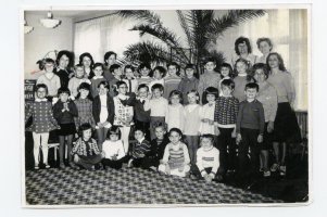 Rok 1965. Przedszkole nr 3, grupa najstarsza. Personel: od lewej Sabina Białoskórska – dyrektorka, NN – wychowawczyni, Krystyna Ślęzak – wychowawczyni. W prawym rogu stoją wychowawczynie: Krystyna Daleka, Zofia Bladowska, niżej Danuta Maszota i DanutaMartyna – również wychowawczynie. Dzieci: bezpośrednio pod kwiatem stoją: Katarzyna Dzitko i Bożena Teofilska, w II rzędzie czwarta od lewej – Iwona Wesołowska. W I rzędzie od lewej – Ewa Młodzińska.