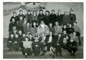 Rok 1955/56. Choinka uczniów klasy VI. W środkowym rzędzie od lewej: Alicja Głowacka - wych. klasy, NN, Mikołaj, praktykantka NN, Stanisław Romanowicz - kier. szkoły, na końcu Jadwiga Jóźwiak - nauczycielka.W najniższym rzędzie nauczycielka Zofia Żbikowska - Wołocznik, dalej Ewa Budkowska, przewodn. Komitetu Rodzicielskiego.