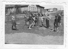  Rok 1954. Uczniowie ćwiczą kujawiaka na boisku szkolnym. Przygotowują się do „Festiwalu Pieśni i Tańca” w Lęborku. Zdjęcie pochodzi z kroniki szkolnej.