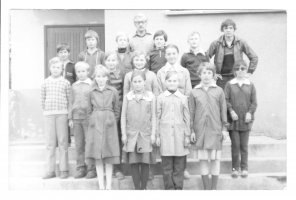Rok szkolny 1982/1983. Na zdjęciu nauczyciel Augustyn Bujak ze swoimi uczniami przed szkołą w Karwicy. Zdjęcie udostępniła Ewa Bujak.