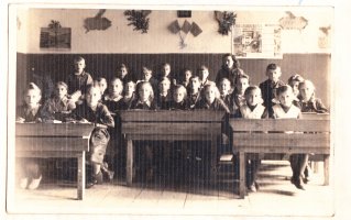 Rok szkolny 1950/1951 (1951/1952?). Na zdjęciu uczniowie ze Szkoły Podstawowej w Karwicy wraz ze swoją wychowawczynią oczekują na ferie letnie. Zdjęcie udostępniła Ewa Bujak.