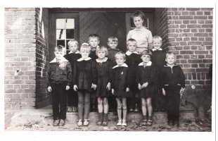 Lata 60. Na zdjęciu nauczycielka Lucyna Szymańska ze swoimi uczniami przed szkołą w Karwicy. Zdjęcie udostępniła Ewa Bujak.