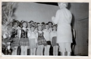  18.01.1969 r. Występ chóru szkolnego podczas choinki noworocznej. Dyryguje kierownik szkoły Krystyna Gadowska. Zdjęcie pochodzi z kroniki szkolnej.