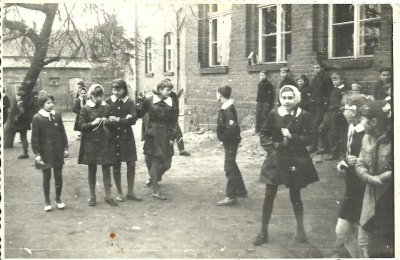 Fotografia przedstawia uczniów przed budynkiem Szkoły Podstawowej w Nowej Wsi Lęborskiej podczas przerwy. Rok: 1967